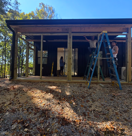 Crew framing the porch on a black metal barndominium